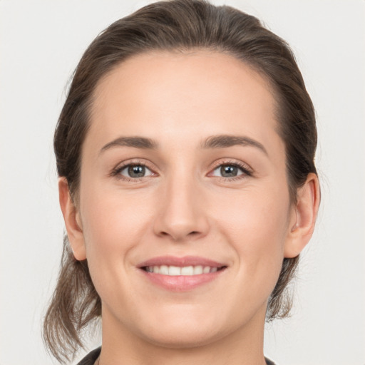 Joyful white young-adult female with medium  brown hair and grey eyes