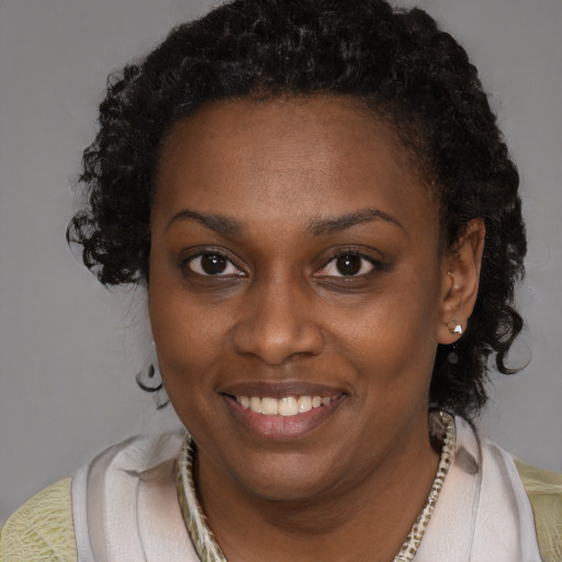 Joyful black young-adult female with short  brown hair and brown eyes