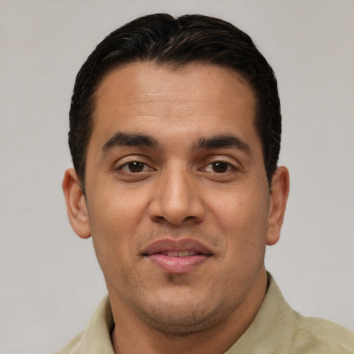 Joyful latino young-adult male with short  brown hair and brown eyes