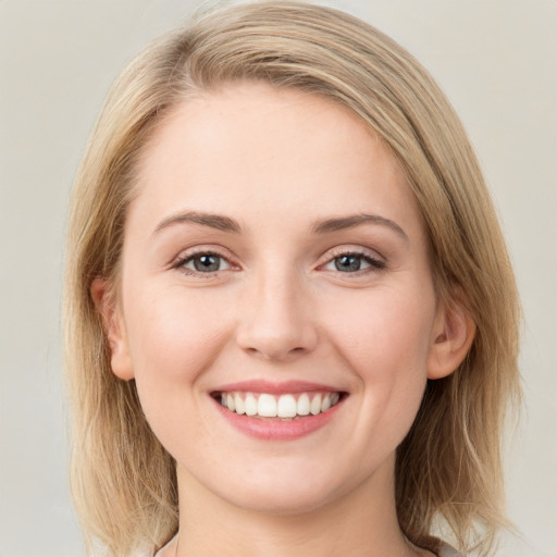 Joyful white young-adult female with long  brown hair and blue eyes