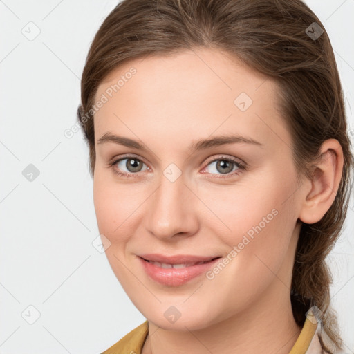 Joyful white young-adult female with medium  brown hair and grey eyes