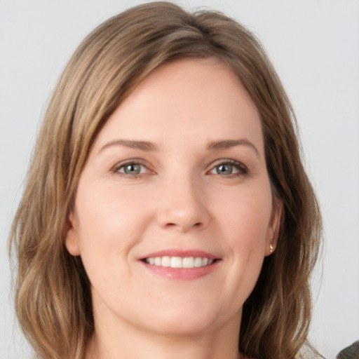 Joyful white young-adult female with medium  brown hair and grey eyes