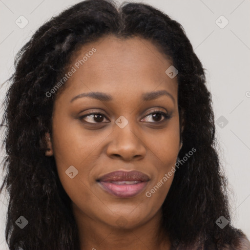 Joyful black young-adult female with long  brown hair and brown eyes