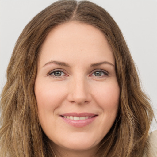 Joyful white young-adult female with long  brown hair and green eyes