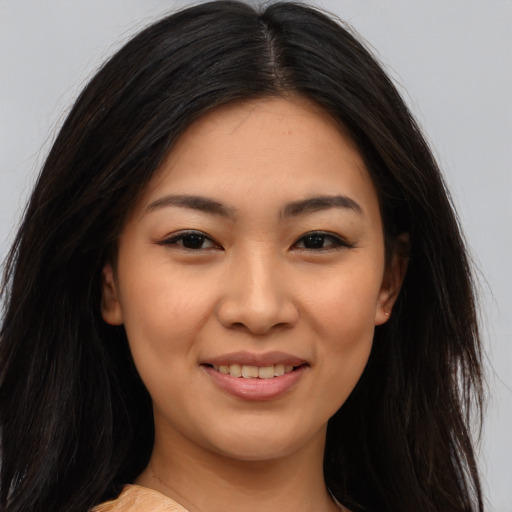 Joyful asian young-adult female with long  brown hair and brown eyes