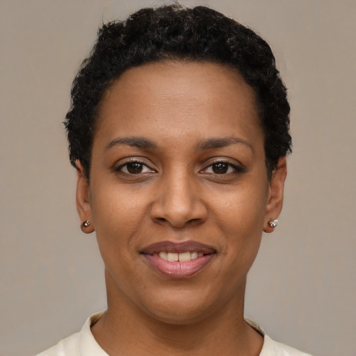 Joyful black young-adult female with short  black hair and brown eyes