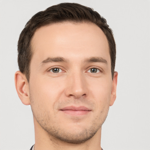 Joyful white young-adult male with short  brown hair and grey eyes