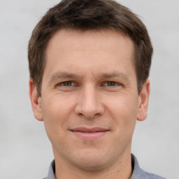 Joyful white adult male with short  brown hair and grey eyes