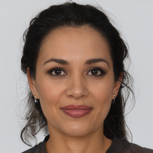Joyful latino young-adult female with medium  brown hair and brown eyes