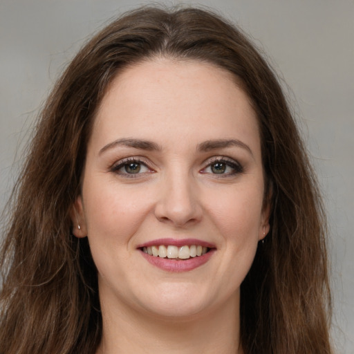 Joyful white young-adult female with long  brown hair and green eyes