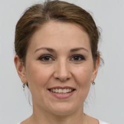 Joyful white adult female with medium  brown hair and grey eyes