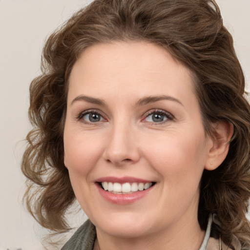 Joyful white young-adult female with medium  brown hair and green eyes