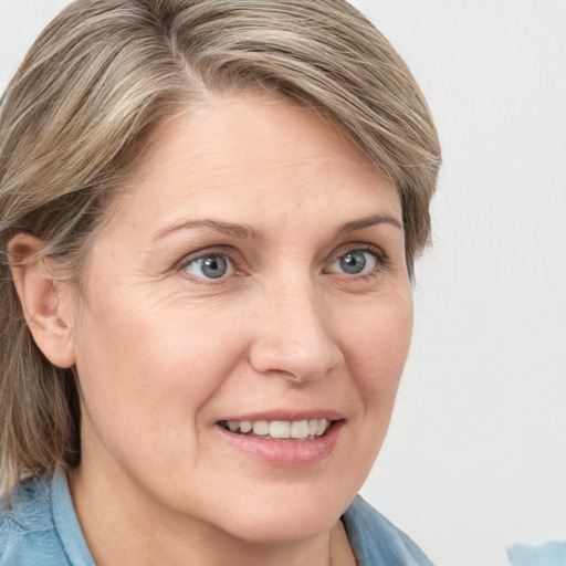 Joyful white adult female with medium  brown hair and blue eyes