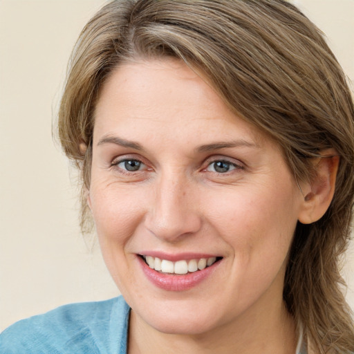 Joyful white adult female with medium  brown hair and blue eyes