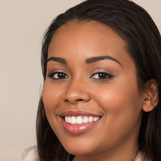 Joyful latino young-adult female with long  brown hair and brown eyes