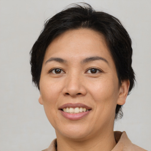 Joyful asian adult female with short  brown hair and brown eyes