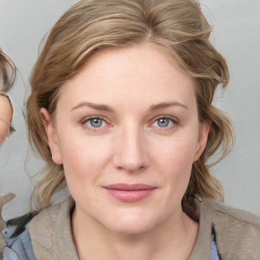 Joyful white young-adult female with medium  brown hair and blue eyes