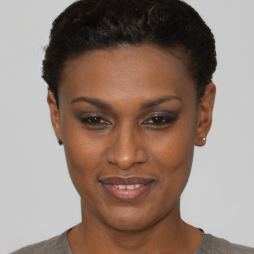 Joyful black young-adult female with short  brown hair and brown eyes