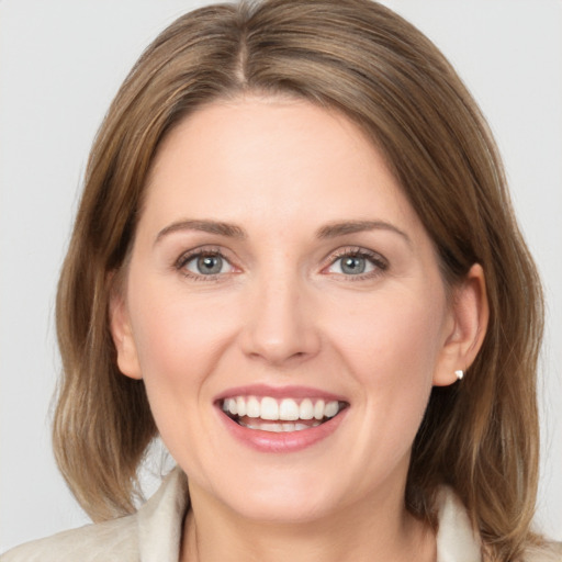 Joyful white young-adult female with medium  brown hair and grey eyes