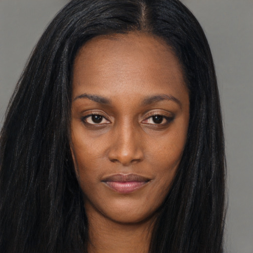 Joyful black young-adult female with long  brown hair and brown eyes