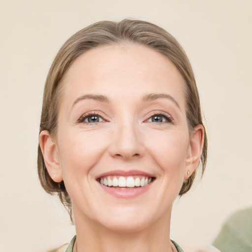 Joyful white adult female with medium  brown hair and green eyes