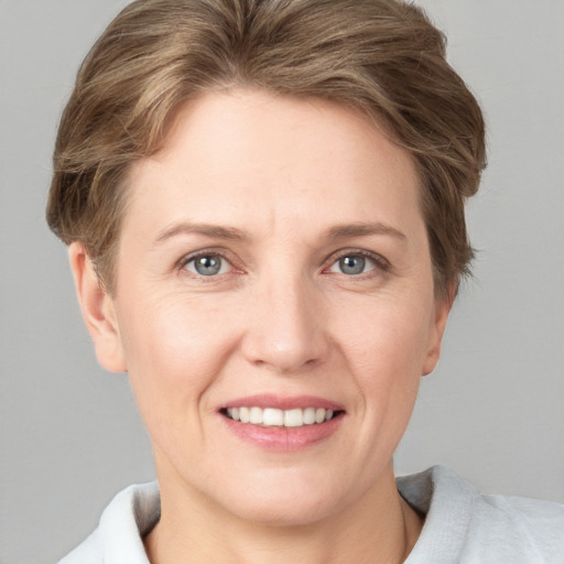 Joyful white adult female with short  brown hair and grey eyes