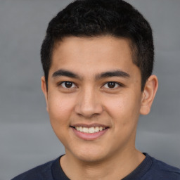 Joyful latino young-adult male with short  brown hair and brown eyes