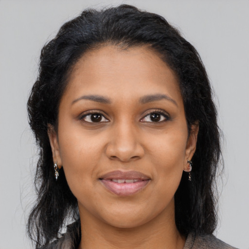 Joyful black young-adult female with long  brown hair and brown eyes