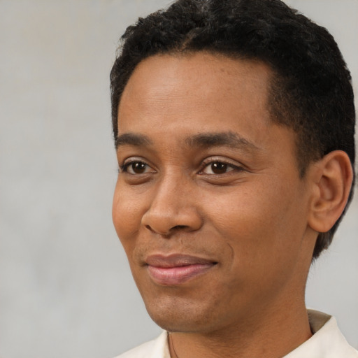 Joyful black young-adult male with short  black hair and brown eyes