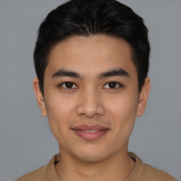 Joyful latino young-adult male with short  brown hair and brown eyes