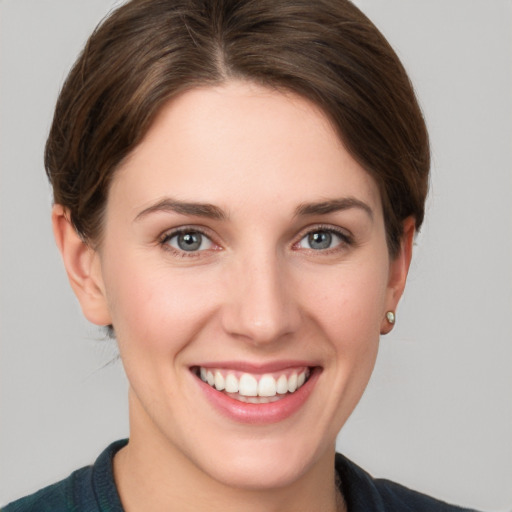 Joyful white young-adult female with short  brown hair and grey eyes