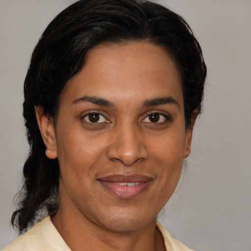 Joyful latino adult female with medium  brown hair and brown eyes