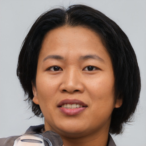Joyful asian adult female with medium  brown hair and brown eyes