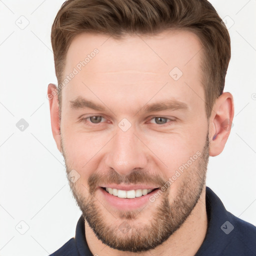 Joyful white young-adult male with short  brown hair and grey eyes