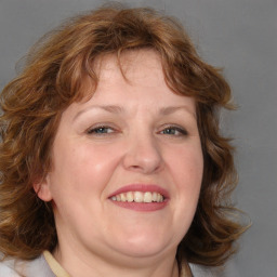 Joyful white adult female with medium  brown hair and blue eyes