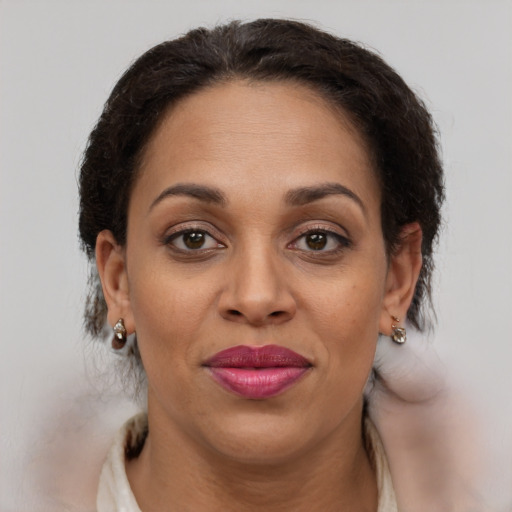 Joyful latino adult female with medium  brown hair and brown eyes