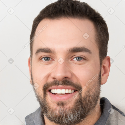 Joyful white young-adult male with short  brown hair and brown eyes