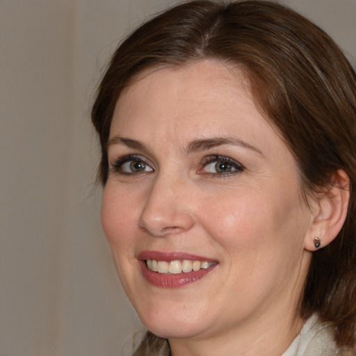 Joyful white adult female with medium  brown hair and blue eyes