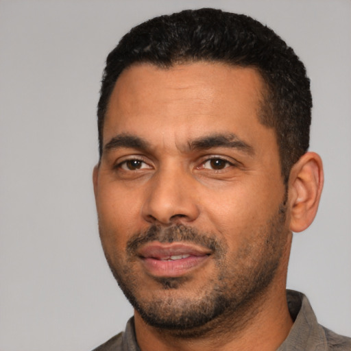 Joyful latino young-adult male with short  black hair and brown eyes