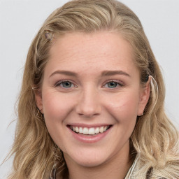 Joyful white young-adult female with long  brown hair and blue eyes