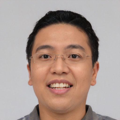 Joyful asian adult male with short  black hair and brown eyes