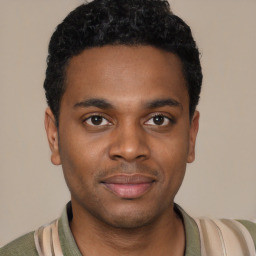 Joyful black young-adult male with short  black hair and brown eyes