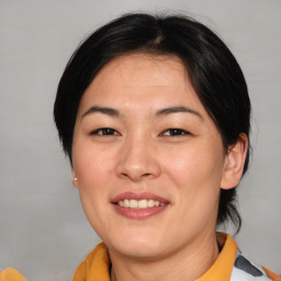 Joyful asian adult female with medium  brown hair and brown eyes