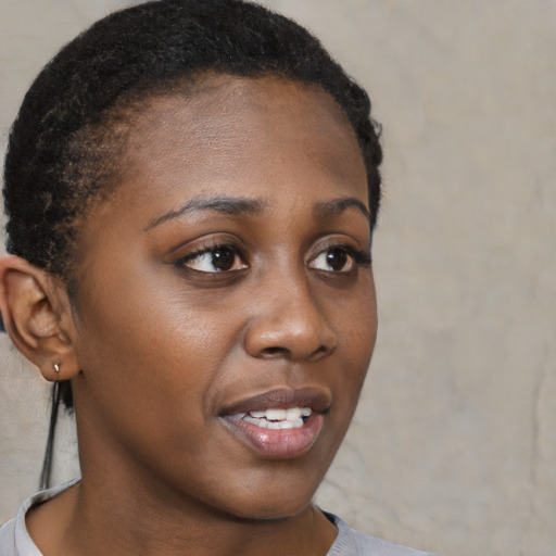 Joyful black young-adult female with short  brown hair and brown eyes
