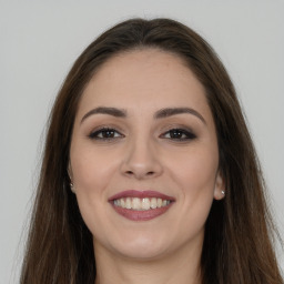 Joyful white young-adult female with long  brown hair and brown eyes