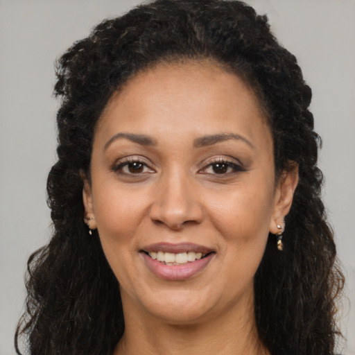 Joyful black adult female with long  brown hair and brown eyes