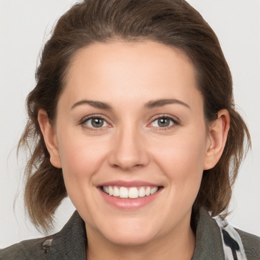 Joyful white young-adult female with medium  brown hair and grey eyes