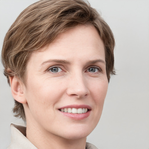 Joyful white young-adult female with short  brown hair and grey eyes