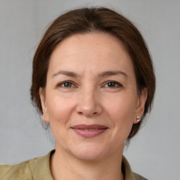 Joyful white adult female with medium  brown hair and grey eyes