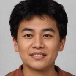 Joyful asian young-adult male with short  brown hair and brown eyes